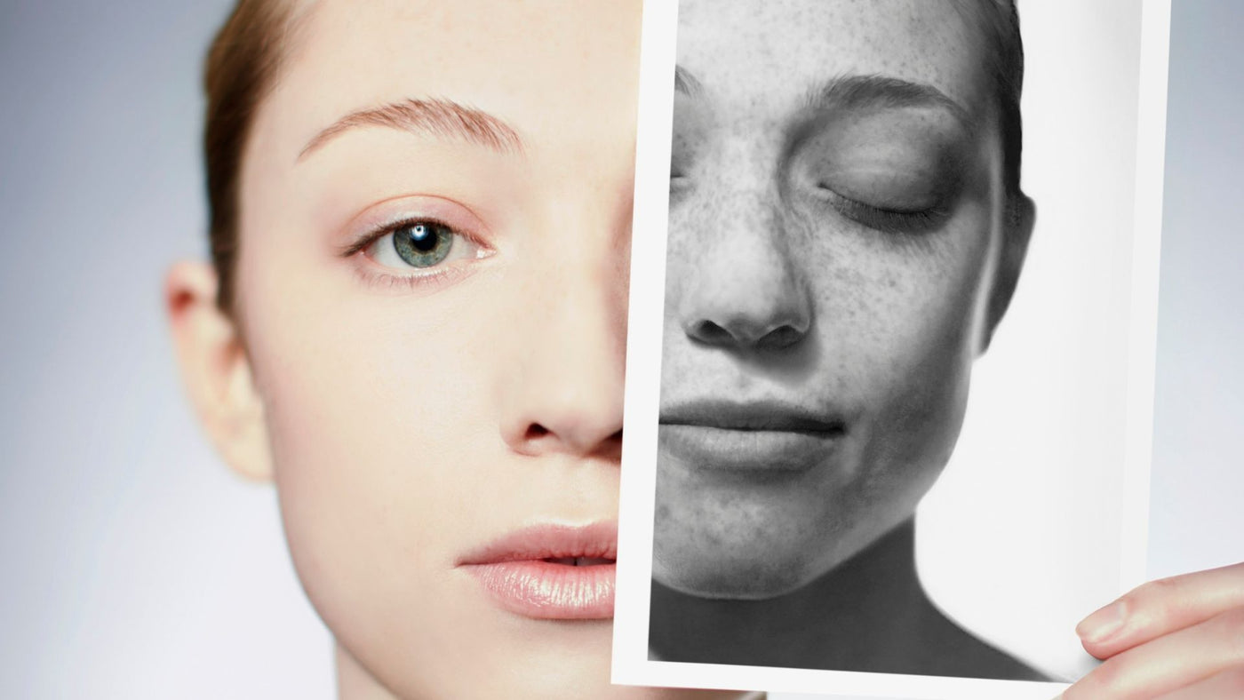 Person holding a black and white photo of a face next to their own face.